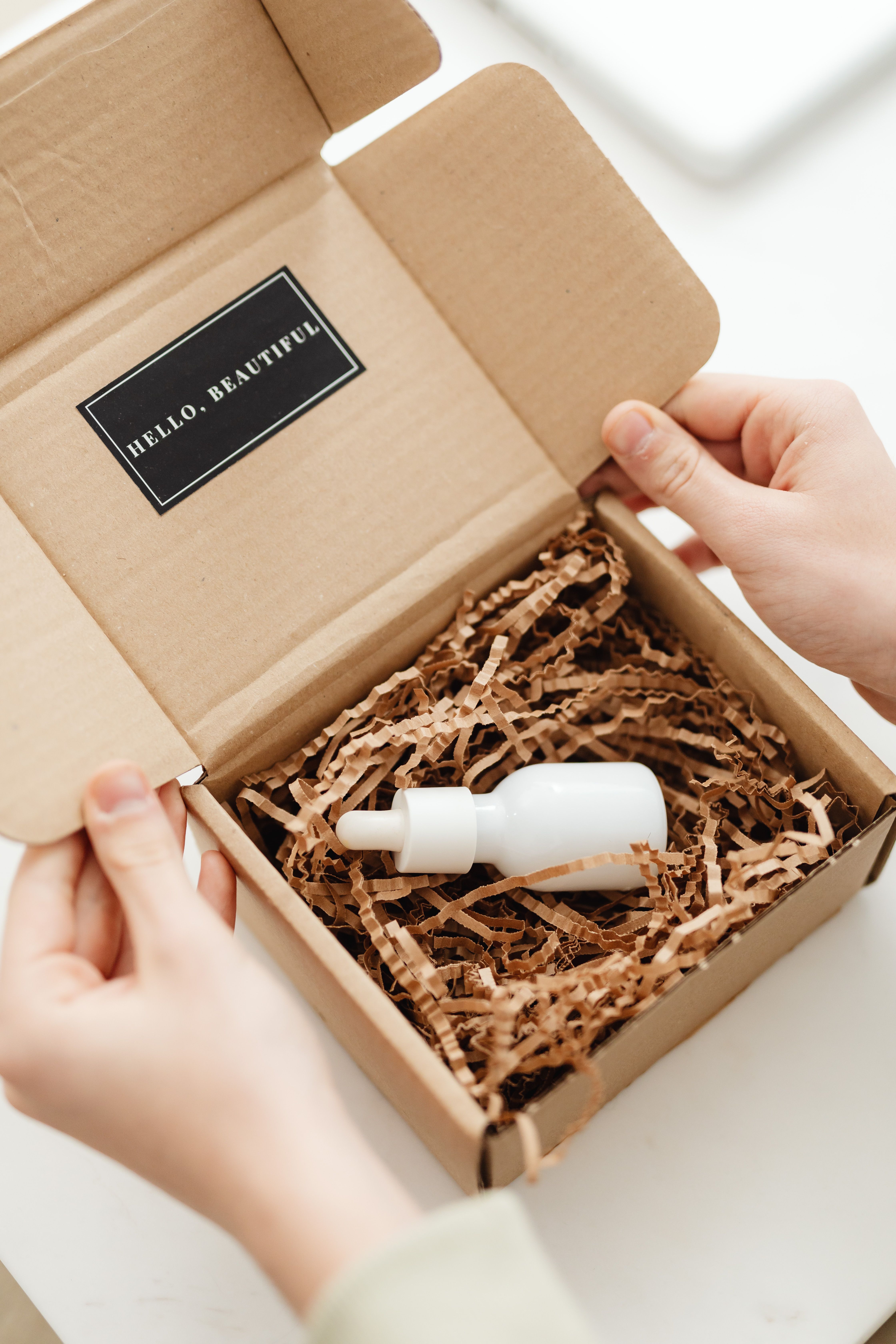 Skincare serum packed inside kraft mailer box with paper filler