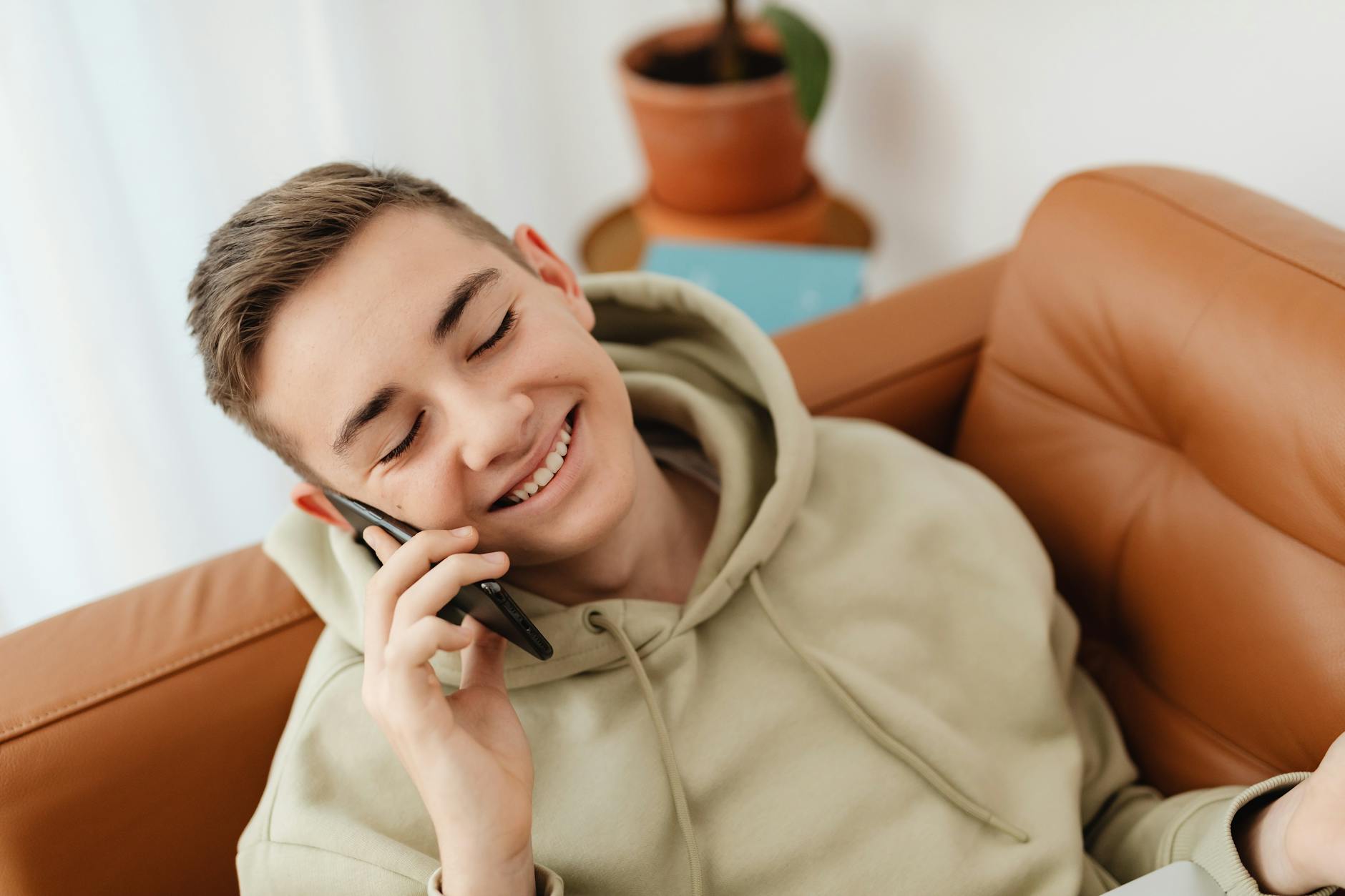 A Young Boy in Hoodie Jacket Talking on the Phone
