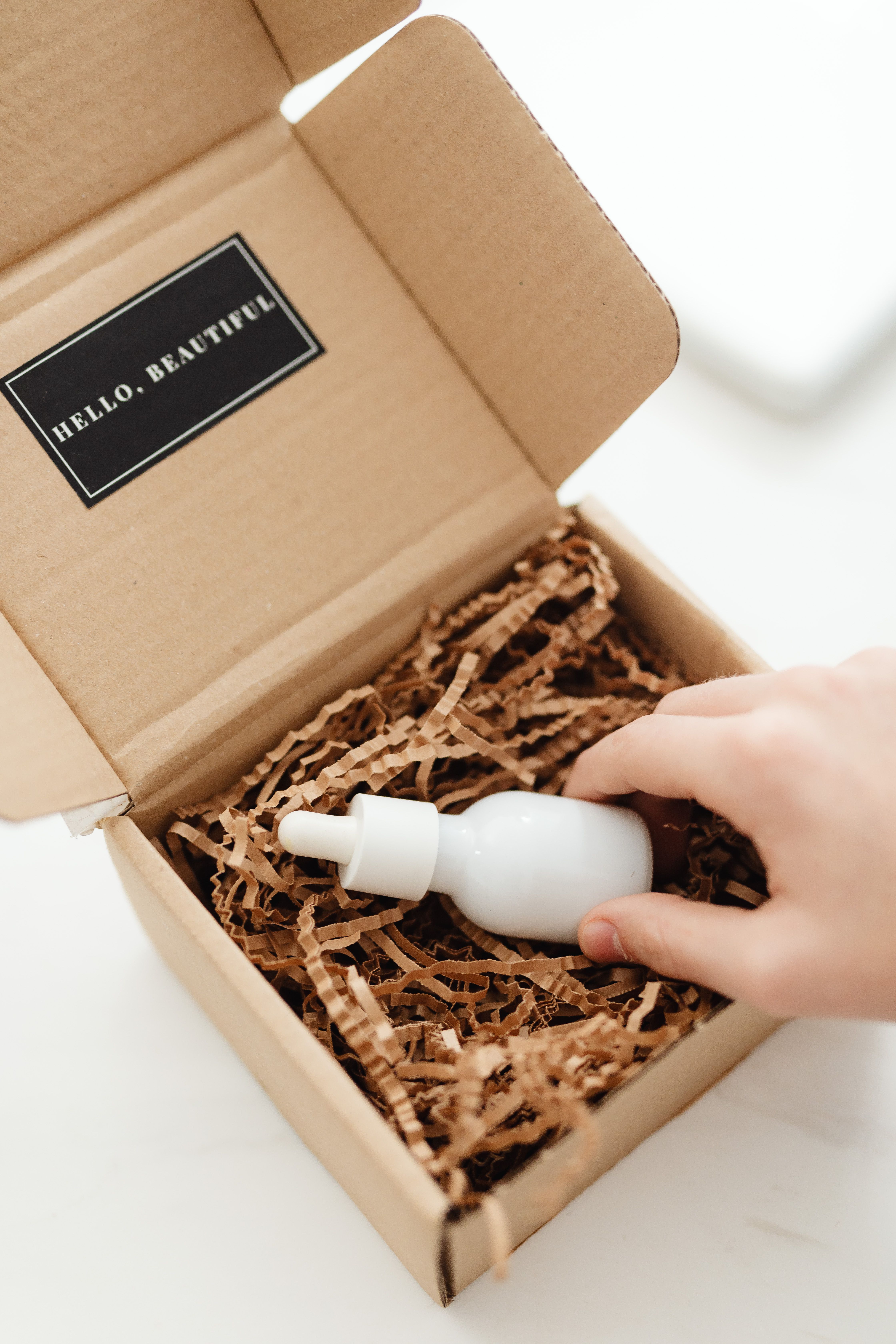 Eco style product packaging with kraft paper filler and a small bottle
