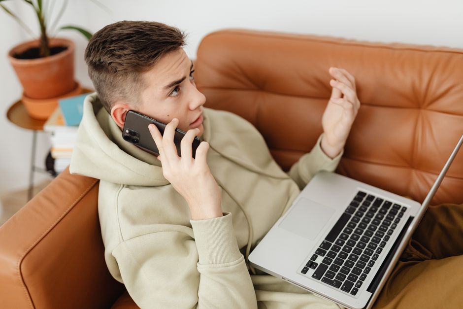 student checking phone laptop research