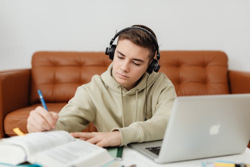 Free Photo of a Boy Doing His Homework while Listening to Music Stock Photo