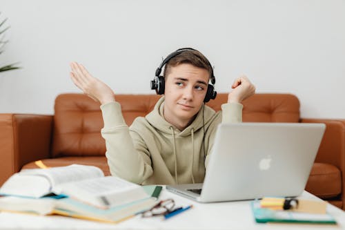 Man in Hoodie Sweater Using a Laptop