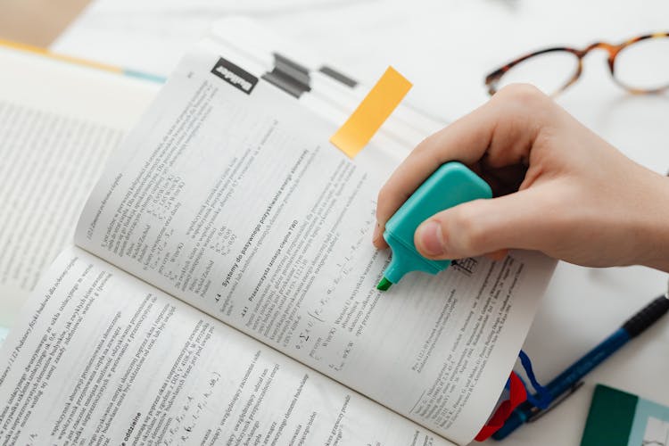 Person Using A Blue Highlighter Pen