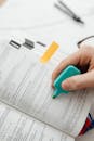 Person Using Blue Highlighter Pen On A Book Page