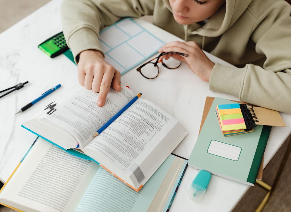 学生在书桌前用荧光笔整理课本与笔记