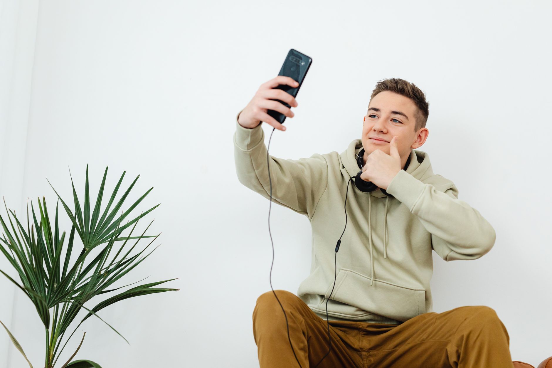 Person taking a selfie in soft window light, the setup that gives any AI rater its cleanest input