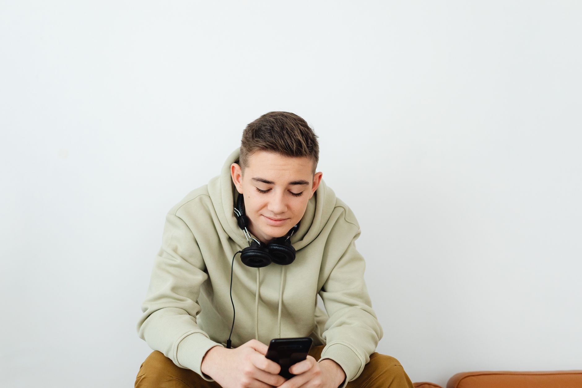 Young person enjoying technology, wearing casual clothes and headphones.