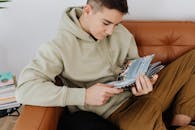 Close-Up Shot of a Boy in a Hoodie Reading a Book