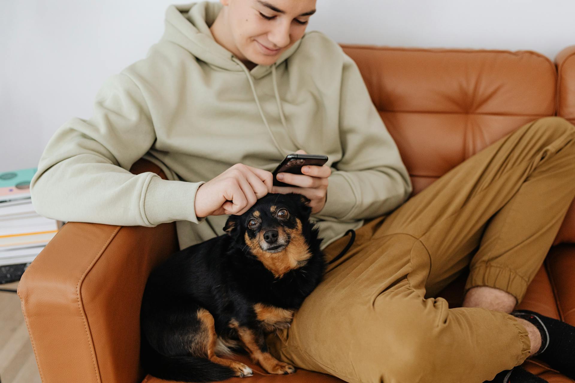 Young Man Sitting with a Dog on a Sofa