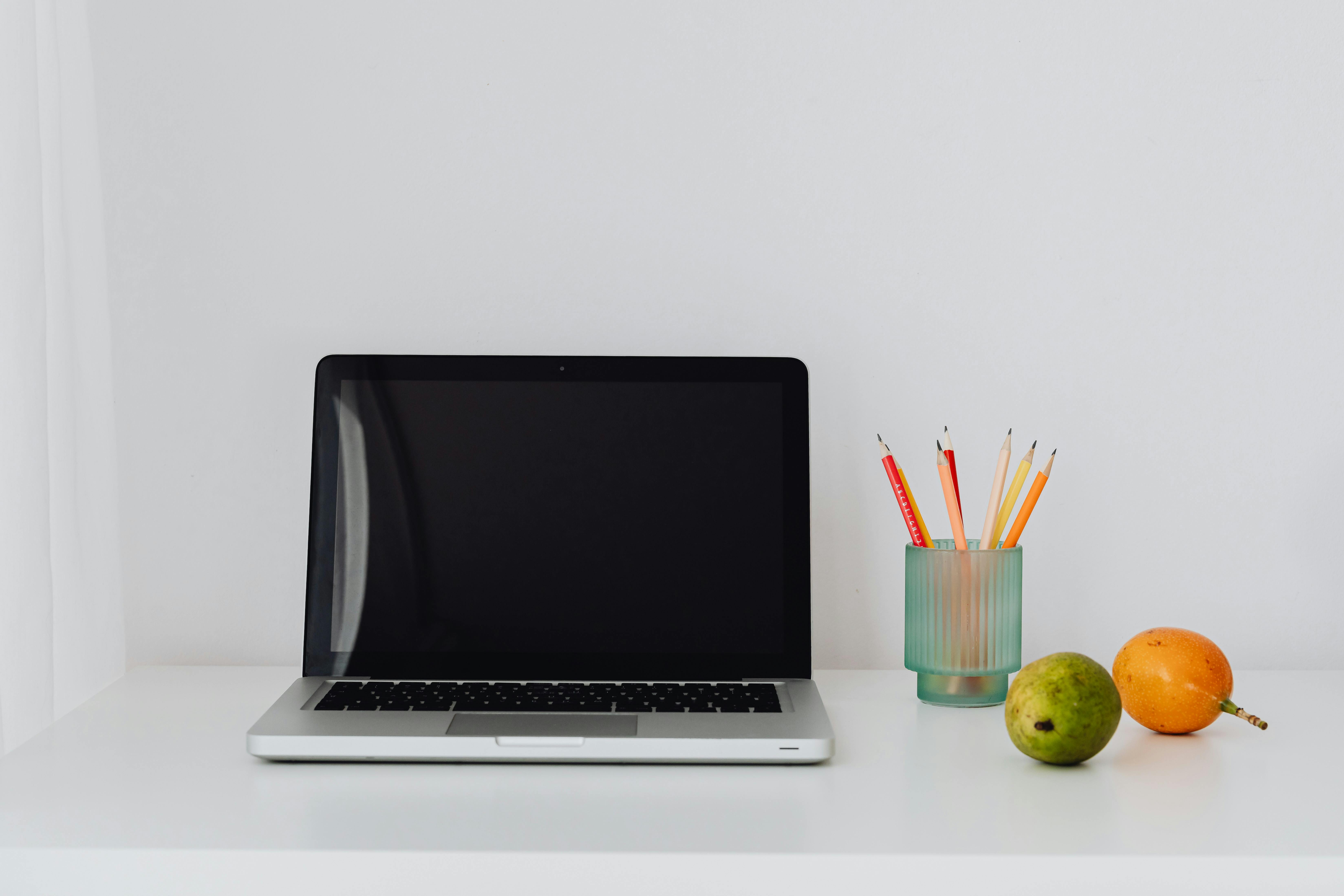 Person placing a laptop on a compact, foldable bedside table in a minimalist bedroom in Thane, India