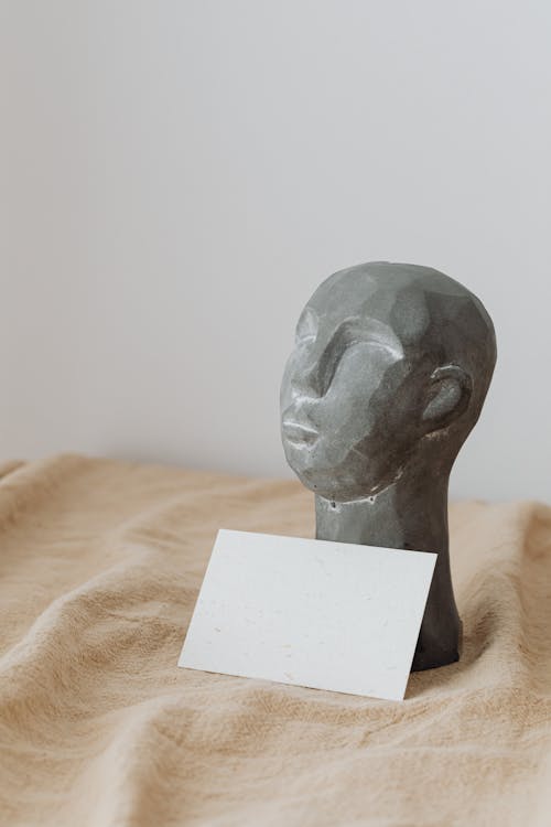 Head Figurine and Paper Sheet