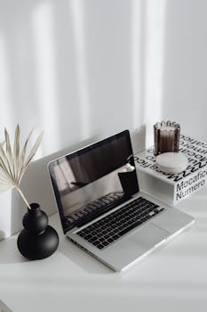 A sleek laptop on a minimalist desk with stylish decor, perfect for a contemporary home office setup.