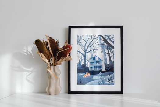 Elegant minimalist interior featuring framed art and decorative vase on a white surface.