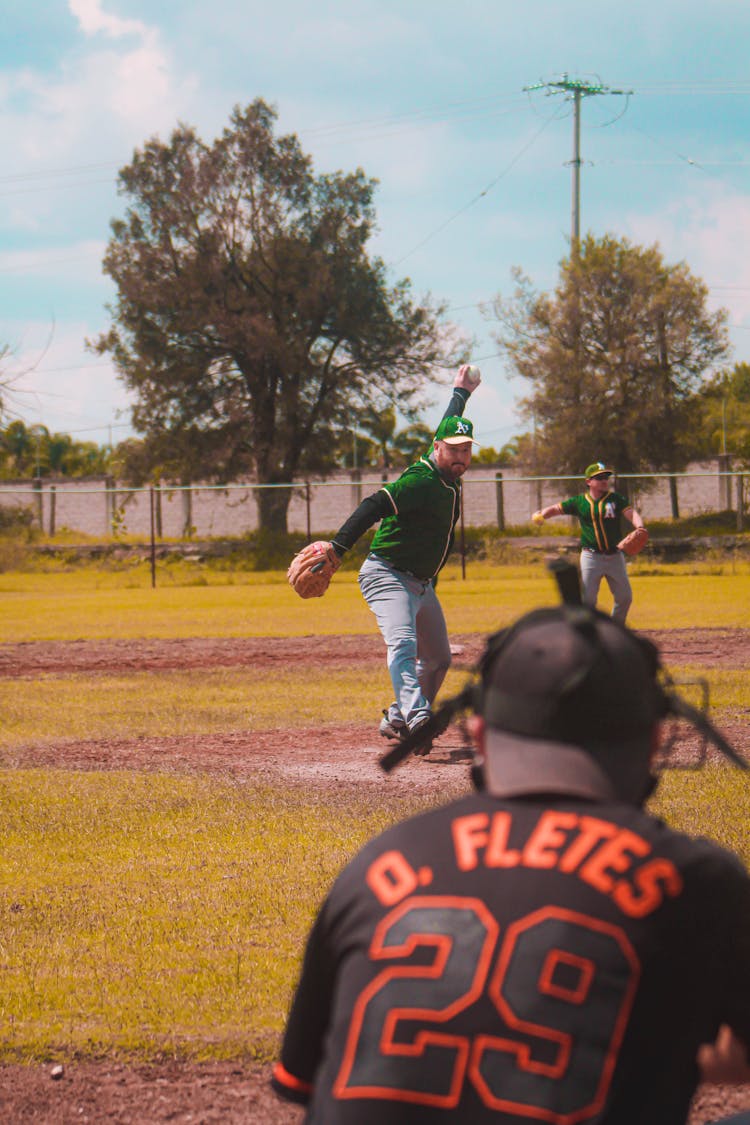 A Group Of Men In Uniforms Playing Baseball In The Field