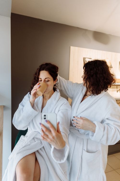 Free A couple in white bathrobes enjoying coffee together indoors, capturing a relaxed morning moment. Stock Photo