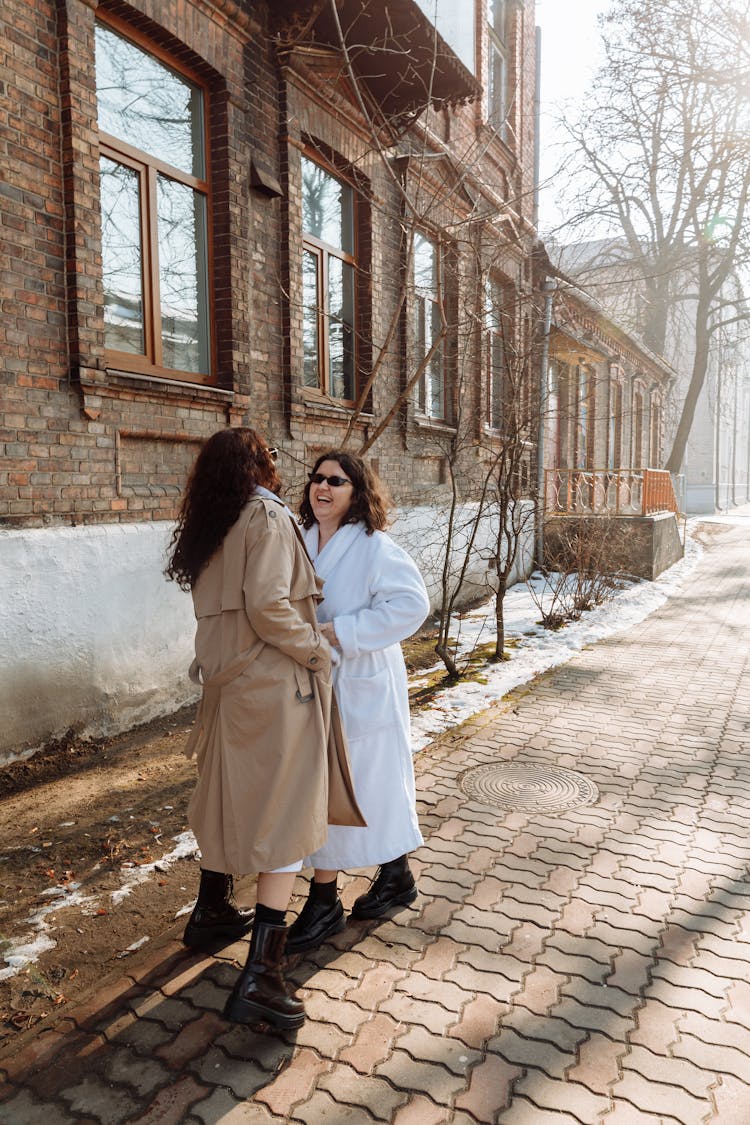 Woman In White Coat Standing On Sidewalk