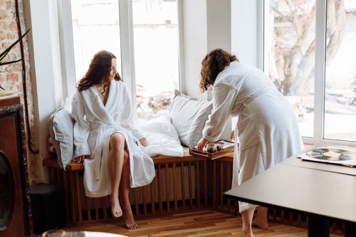 Free Two women in bathrobes sharing a leisurely morning with coffee indoors. Stock Photo