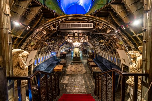 Explore a captivating restaurant designed inside an airplane's interior with artistic features.