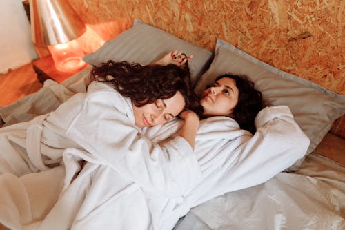 Free Women Lying on Bed Together Stock Photo