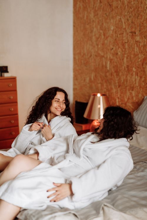 Free A loving couple sharing a moment of affection while relaxing in bathrobes on a comfortable bed. Stock Photo