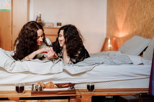 Free Women Lying on Bed Together Stock Photo