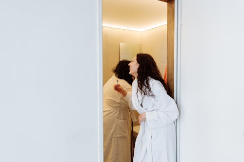 Woman in White Robe Standing Beside Woman in White Robe