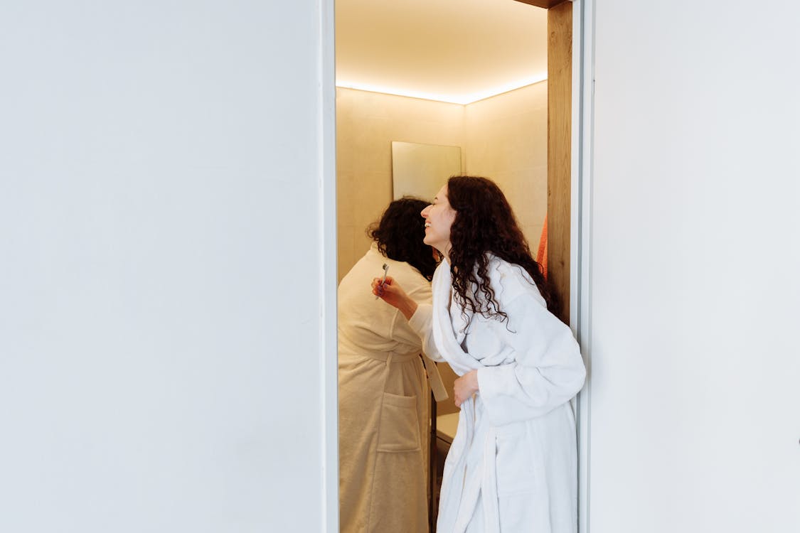 Woman in White Robe Standing Beside Woman in White Robe