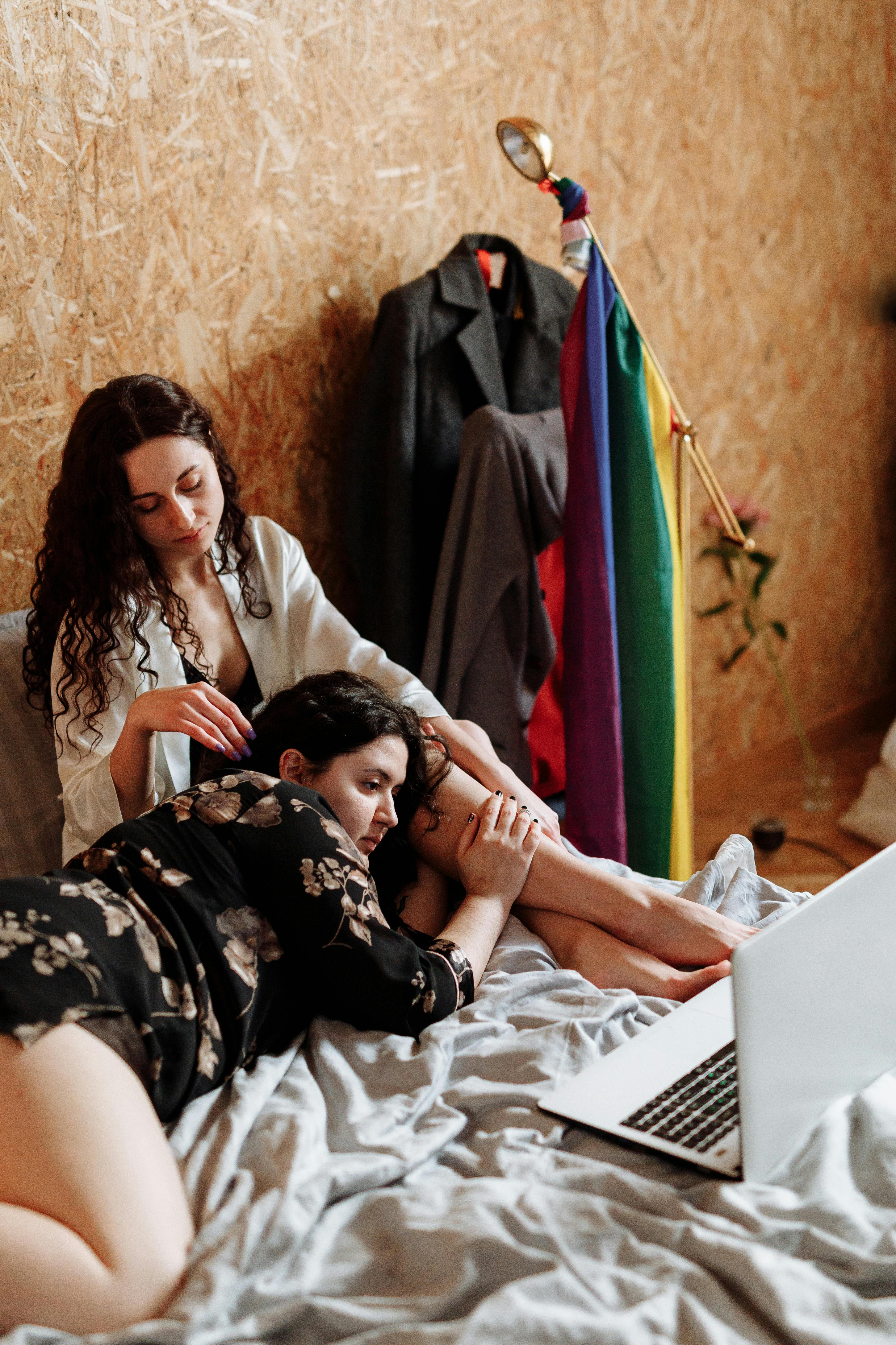 Cozy indoor scene of a loving LGBTQ couple relaxing together with a laptop.