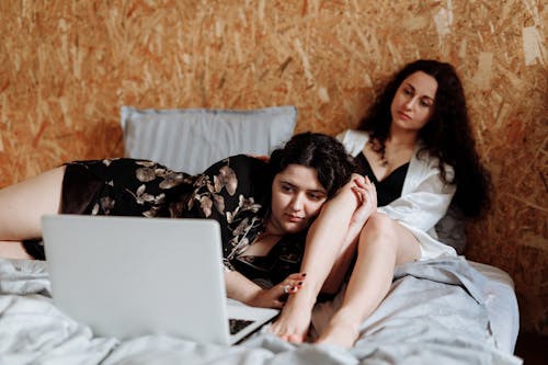 Free Women Watching on Laptop in Bed Stock Photo