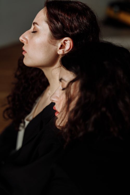 Free Side profile of two women with closed eyes in serene indoor setting. Stock Photo