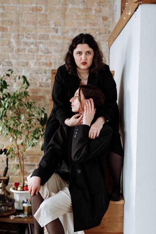Free A fashionable couple in black attire shares a moment indoors, exuding elegance and intimacy. Stock Photo