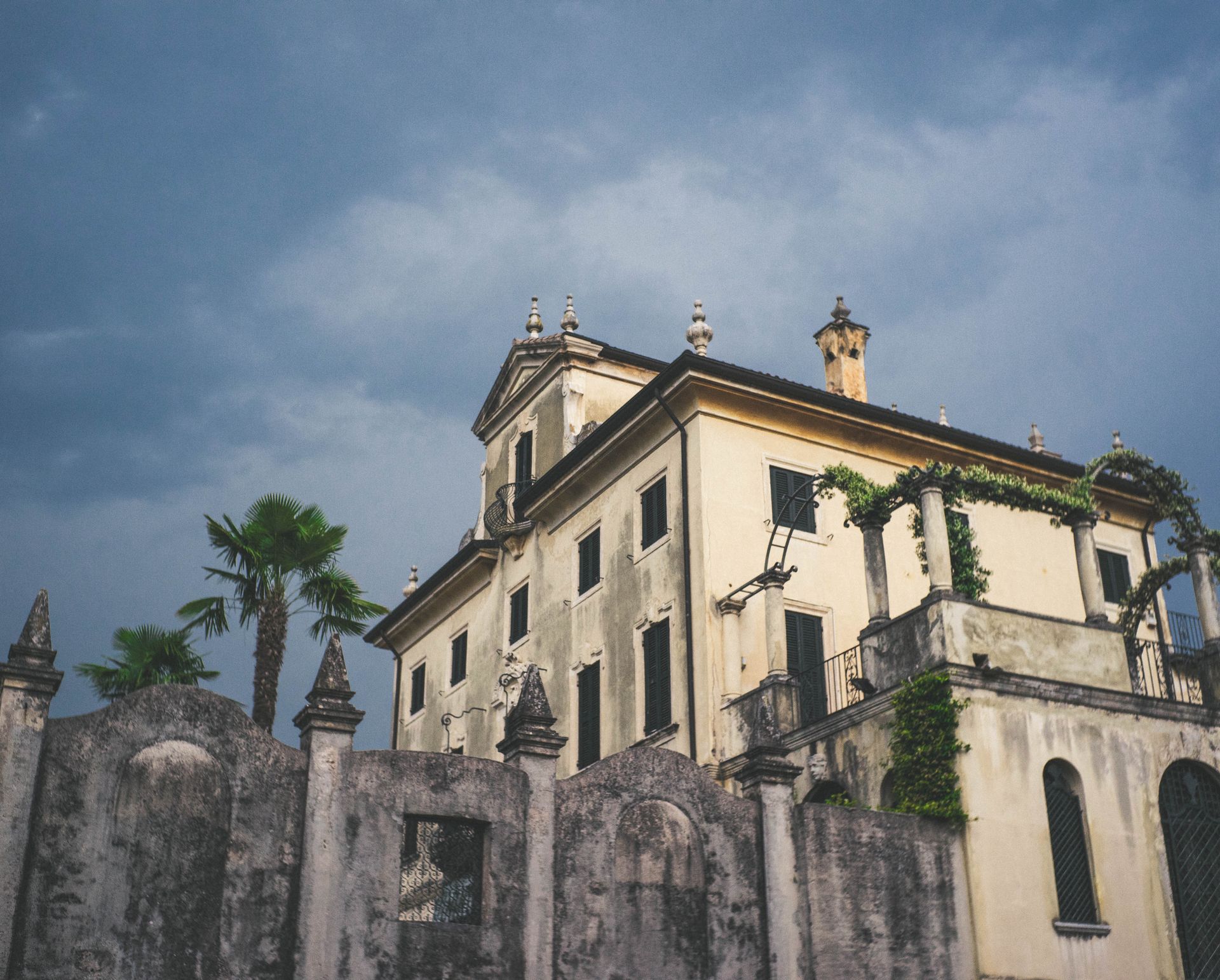 Charming vintage mansion facade in Bardolino, Veneto, Italy against a dramatic sky.