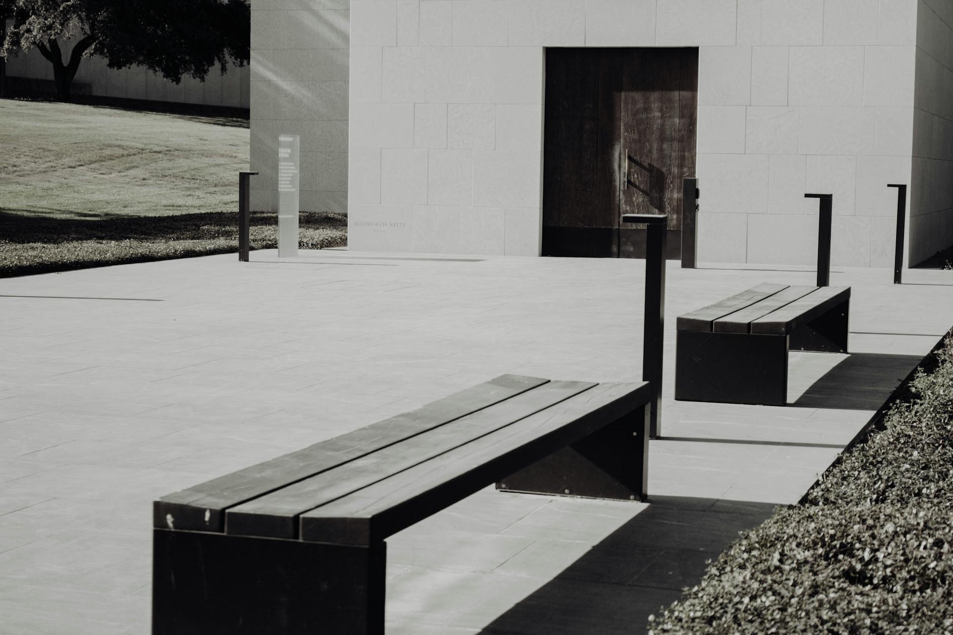 Minimalist modern outdoor seating area with benches and concrete architecture.