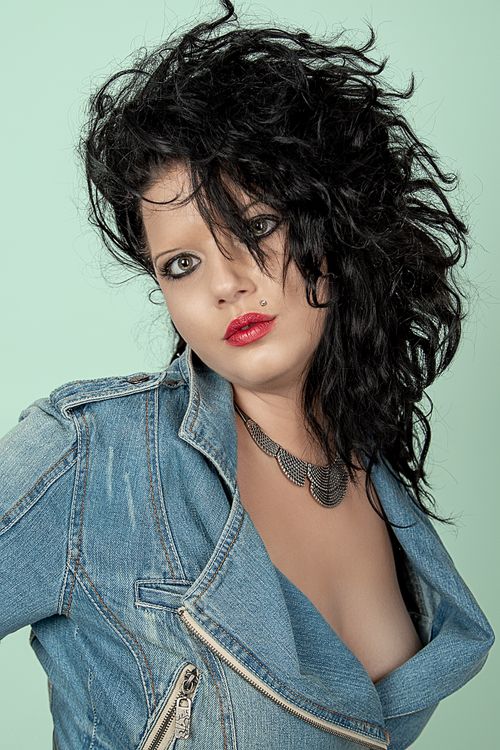 Free Portrait photography featuring a stylish woman with black hair in a denim jacket, showcasing a bold look. Stock Photo