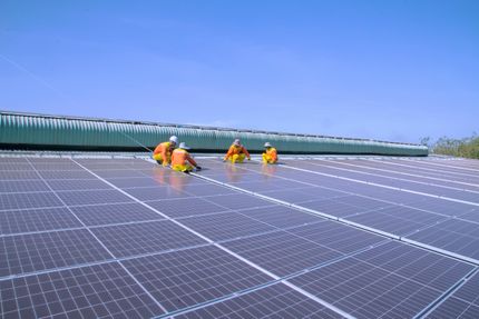 Workers installing solar panels on a rooftop