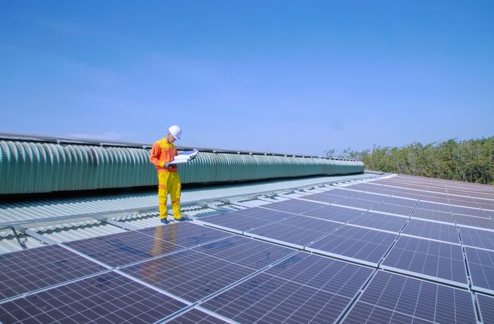 Technician inspecting solar panels during a maintenance visit