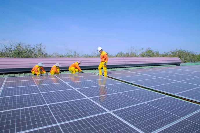 Workers installing solar panels on a residential rooftop