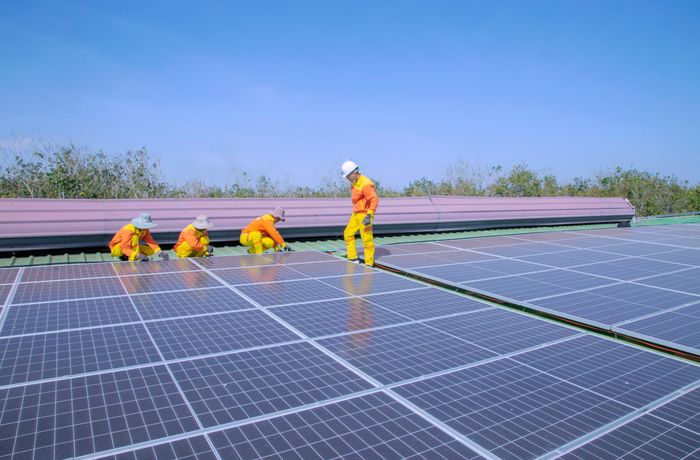 Workers installing solar panels on a residential rooftop