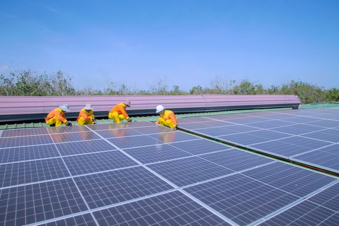 Workers installing solar panels on a sunny day