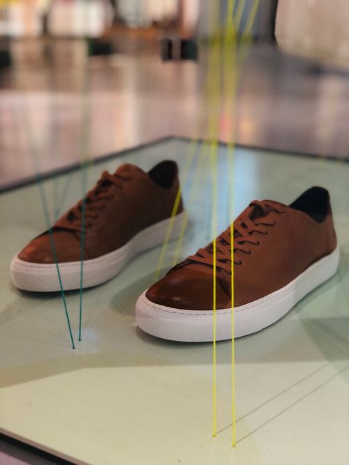 Free Elegant brown sneakers showcased stylishly indoors, perfect for fashion enthusiasts. Stock Photo