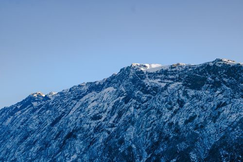 Free Stunning view of snow-covered rocky mountain peaks against a clear blue sky, showcasing winter's beauty and rugged terrain. Stock Photo