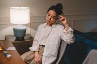 A Woman Sitting on a Chair while Holding a Green Chip