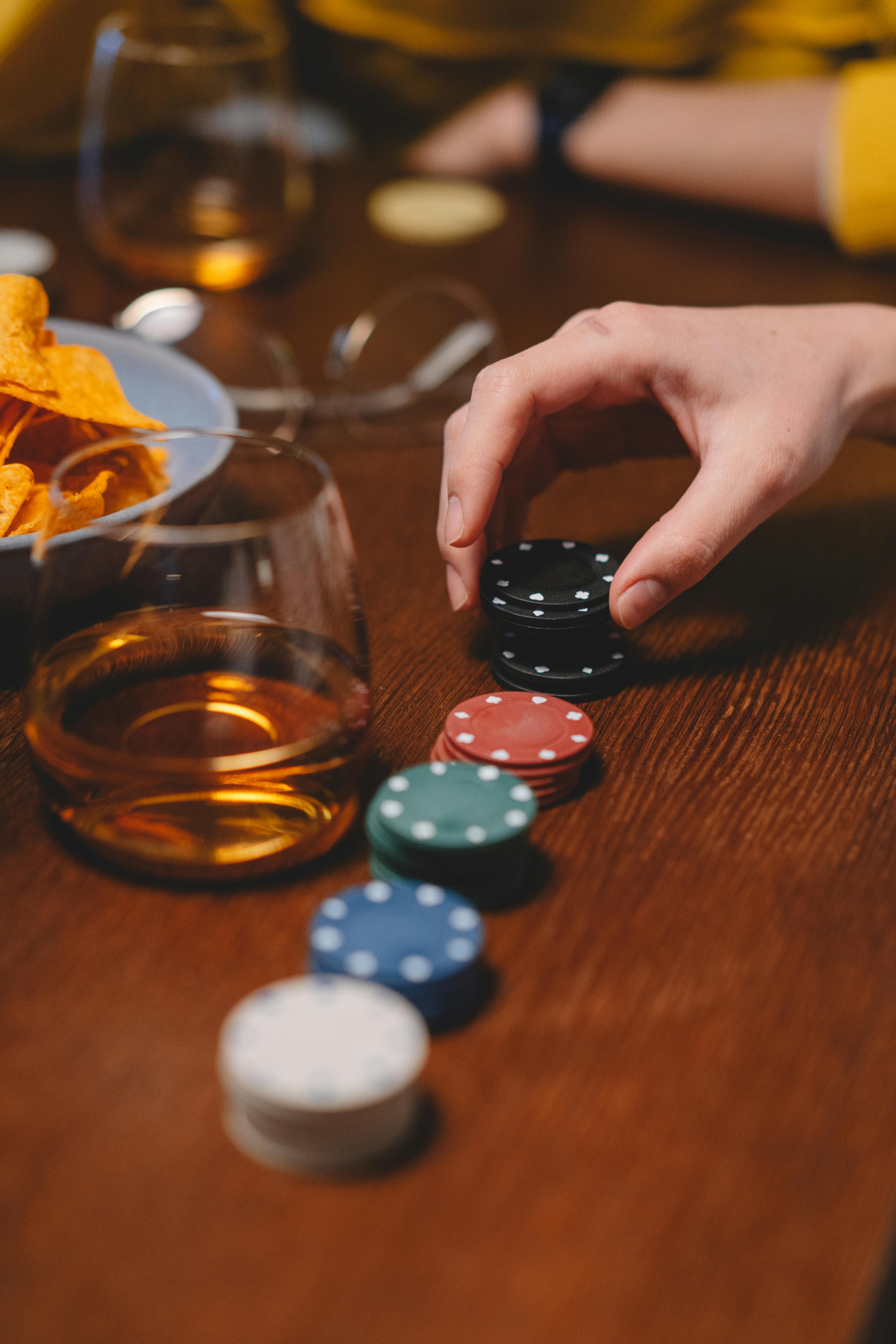 a person holding a poker chips on a wooden table