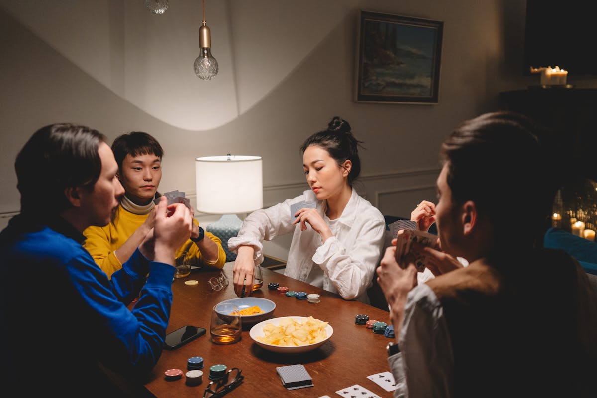 A Group of Friends Playing Poker while Having Conversation