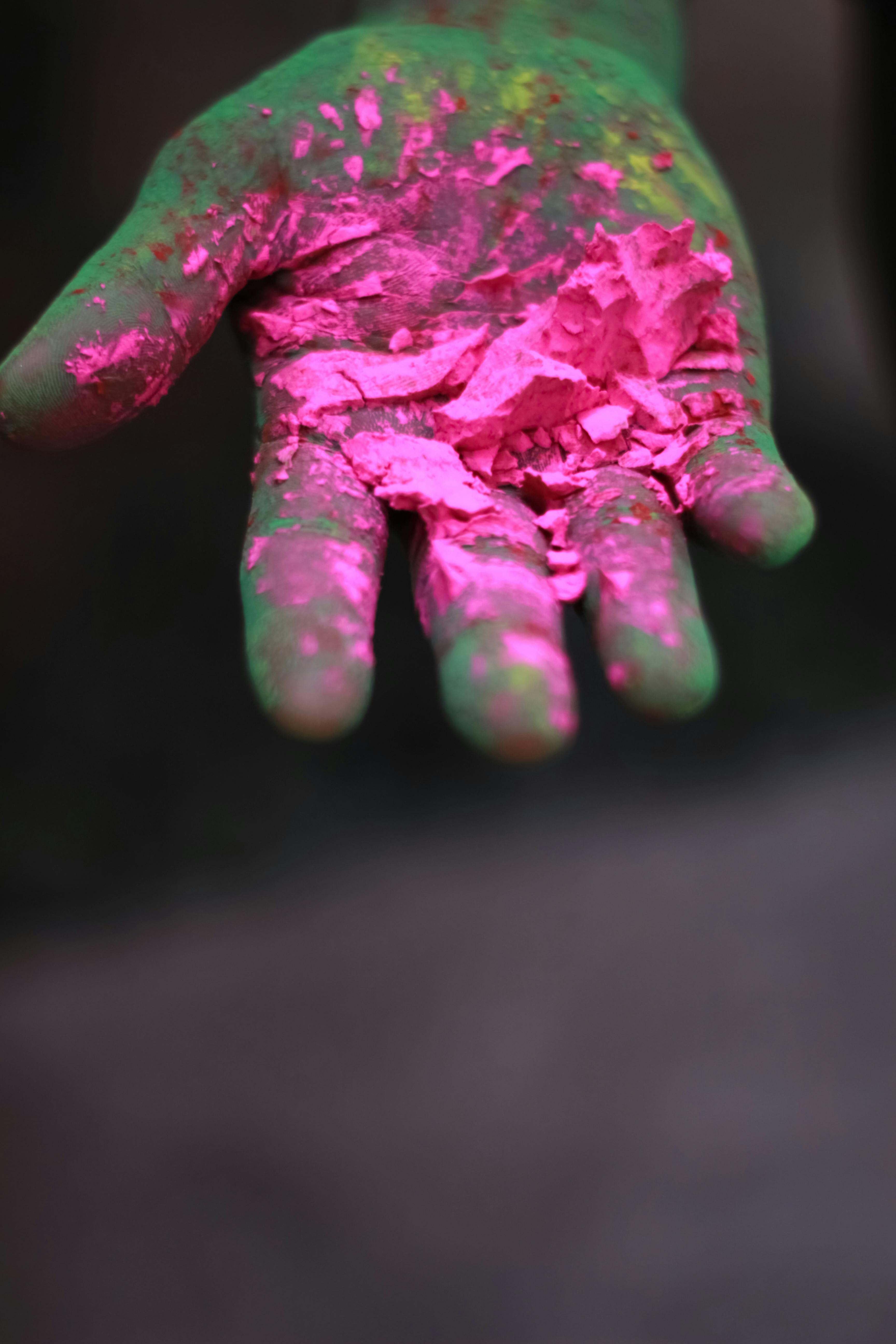 A vibrant close-up of a hand holding colorful pink Holi powder, perfect for festival themes.