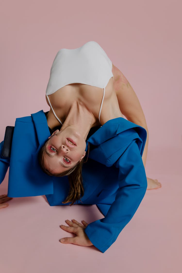 A Woman In Blue Coat Doing Acrobat