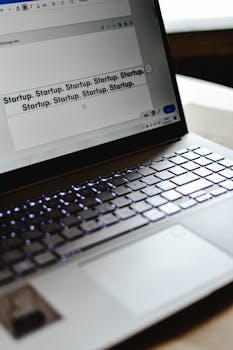 Close-up of a laptop displaying repeated 'Startup' text, symbolizing tech innovation.