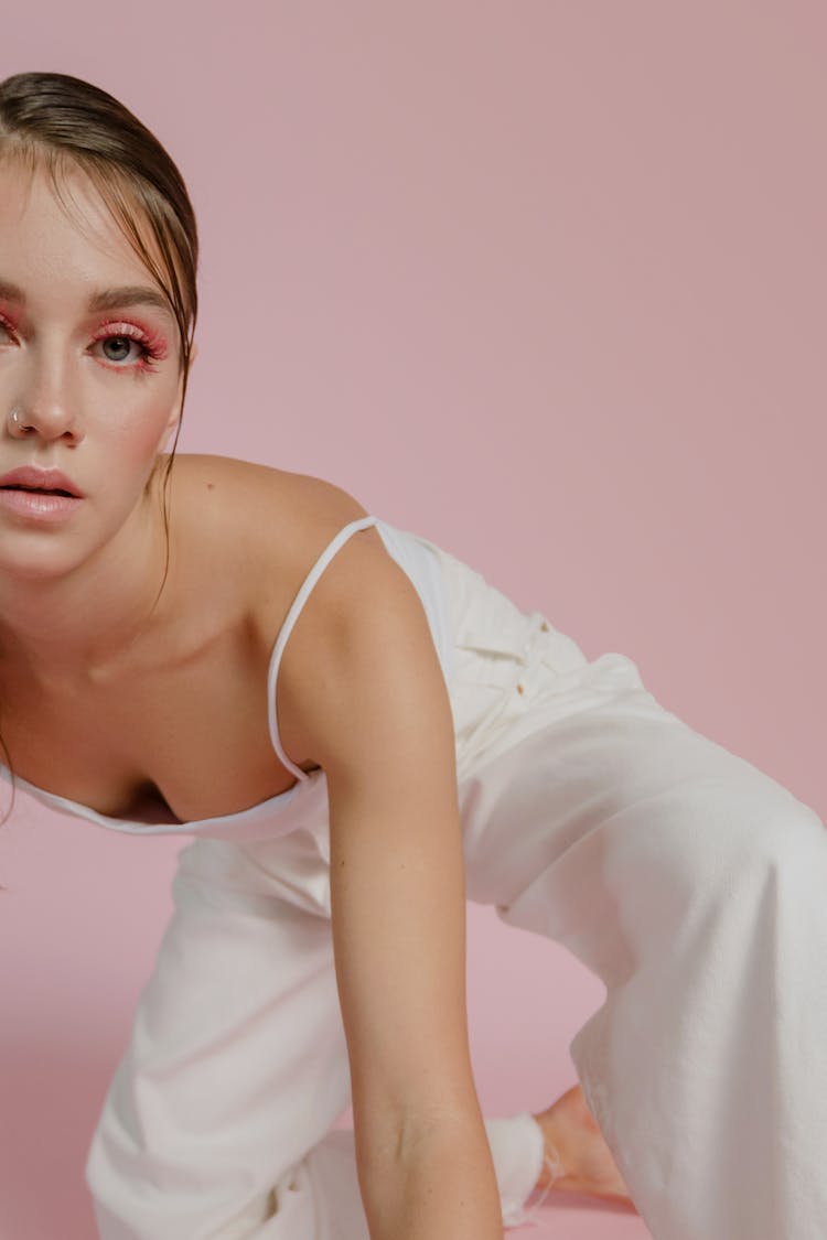 Portrait Of Woman In White Apparel And Pink Makeup Against Pink Background