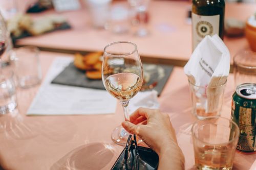 Free A hand holding a wine glass at an elegant dining setting, perfect for celebrations. Stock Photo