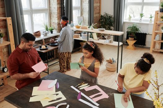 A family enjoys creative quality time crafting together indoors, fostering connection and creativity.